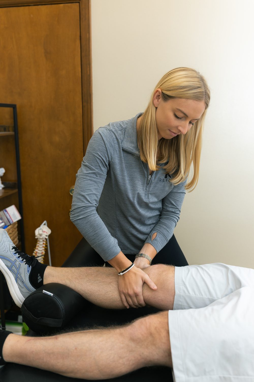 Dr. Dana LaPeze performing hands-on manual therapy on a patient's leg
