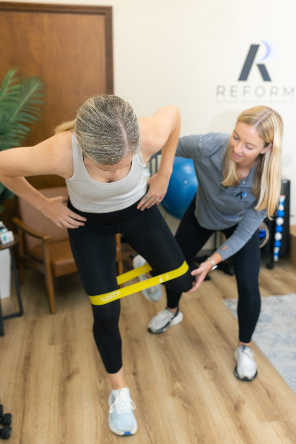 Dr. Dana LaPeze coaching a patient through a resistance band exercise at Reform Physical Therapy